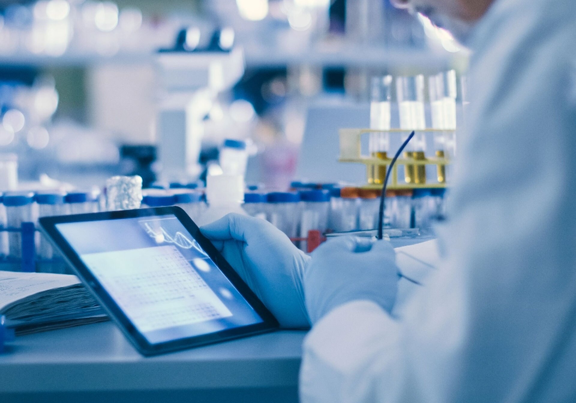 A researcher in a lab looking at a tablet.