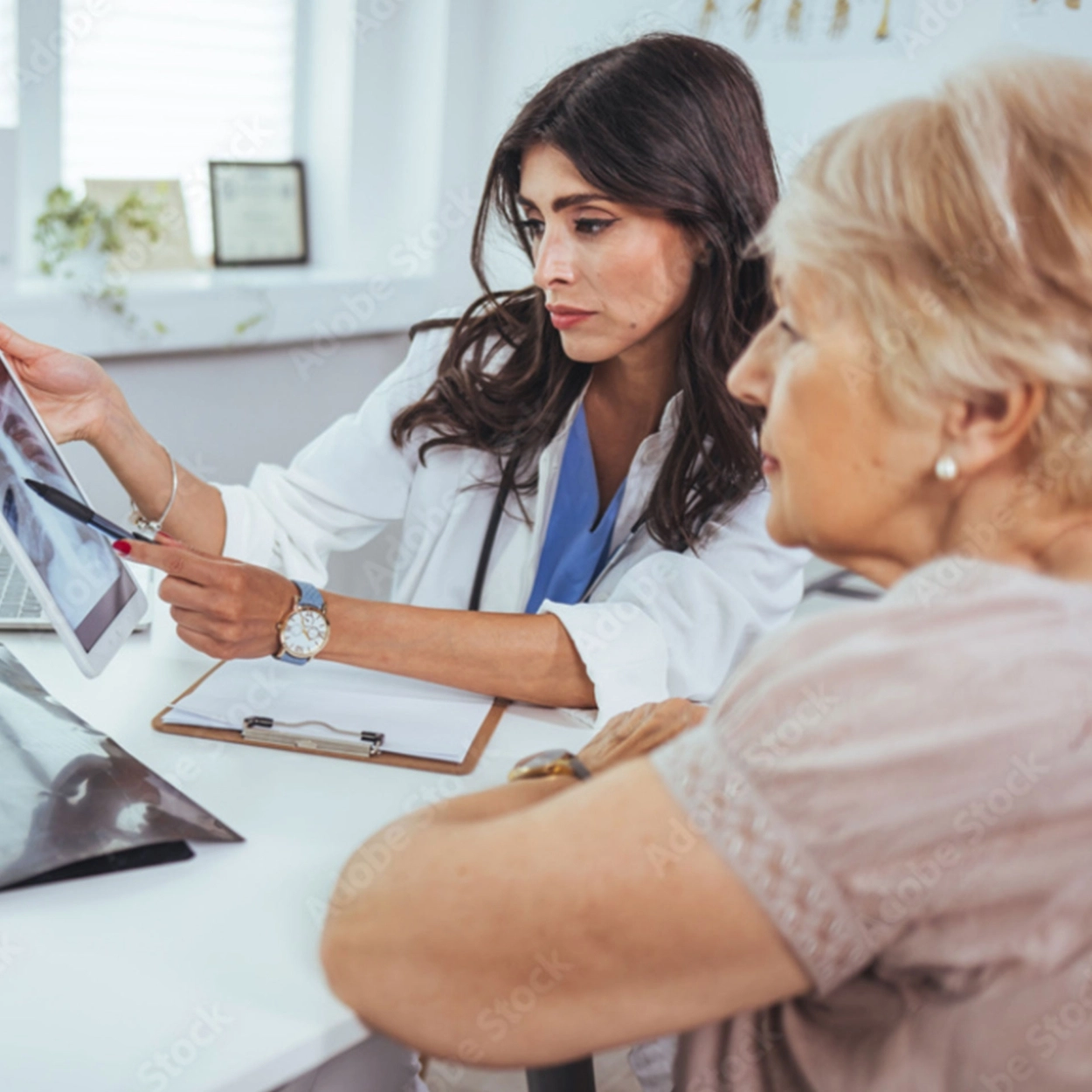 A doctor points to a lung x-ray with a patient.