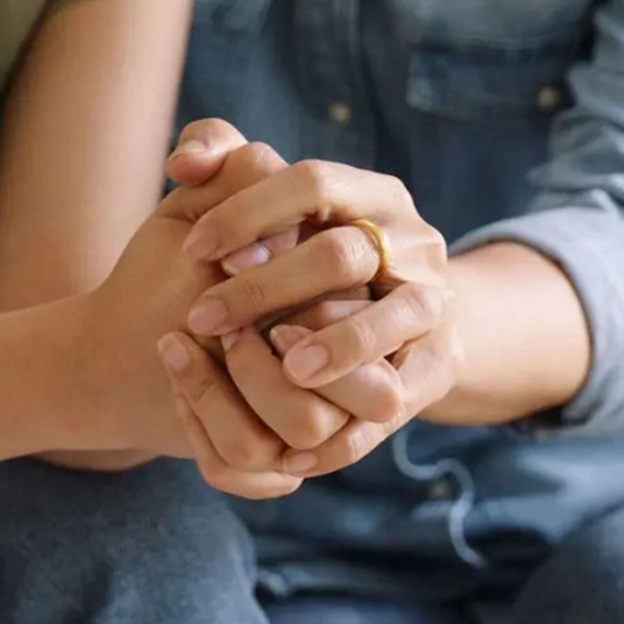 Two people holding hands in support.