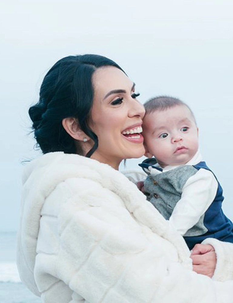 Cropped photo of ALK+ patient Amanda Bialack Stewart holding her baby son.