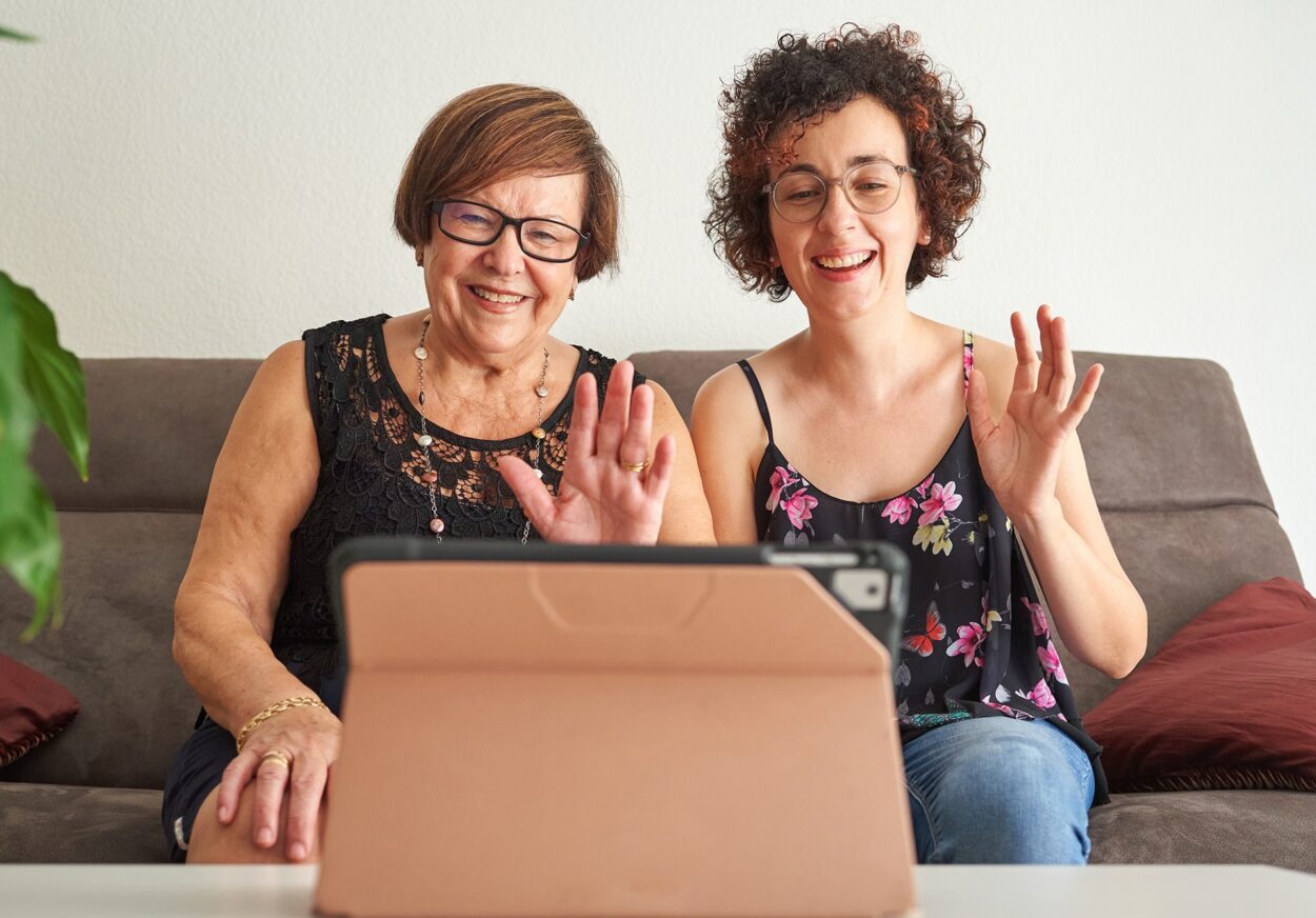 Woman with her daughter makes a video call via tablet.