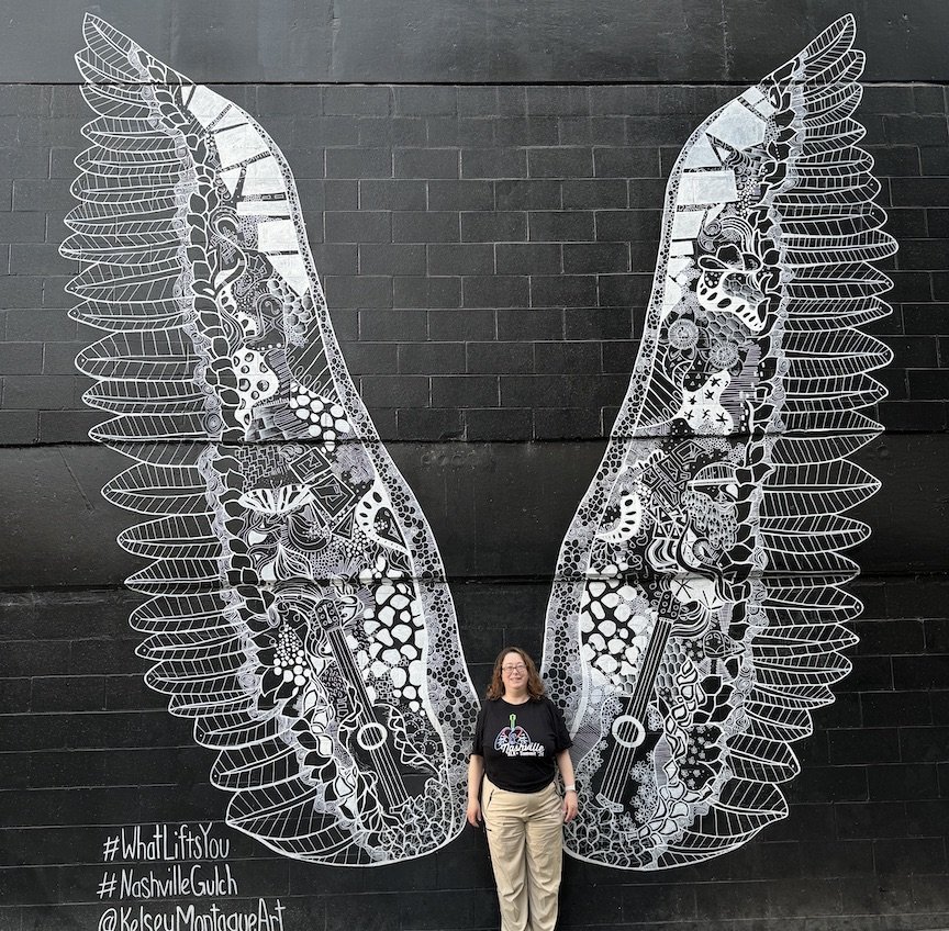 Dana Querido with angel wings artwork.