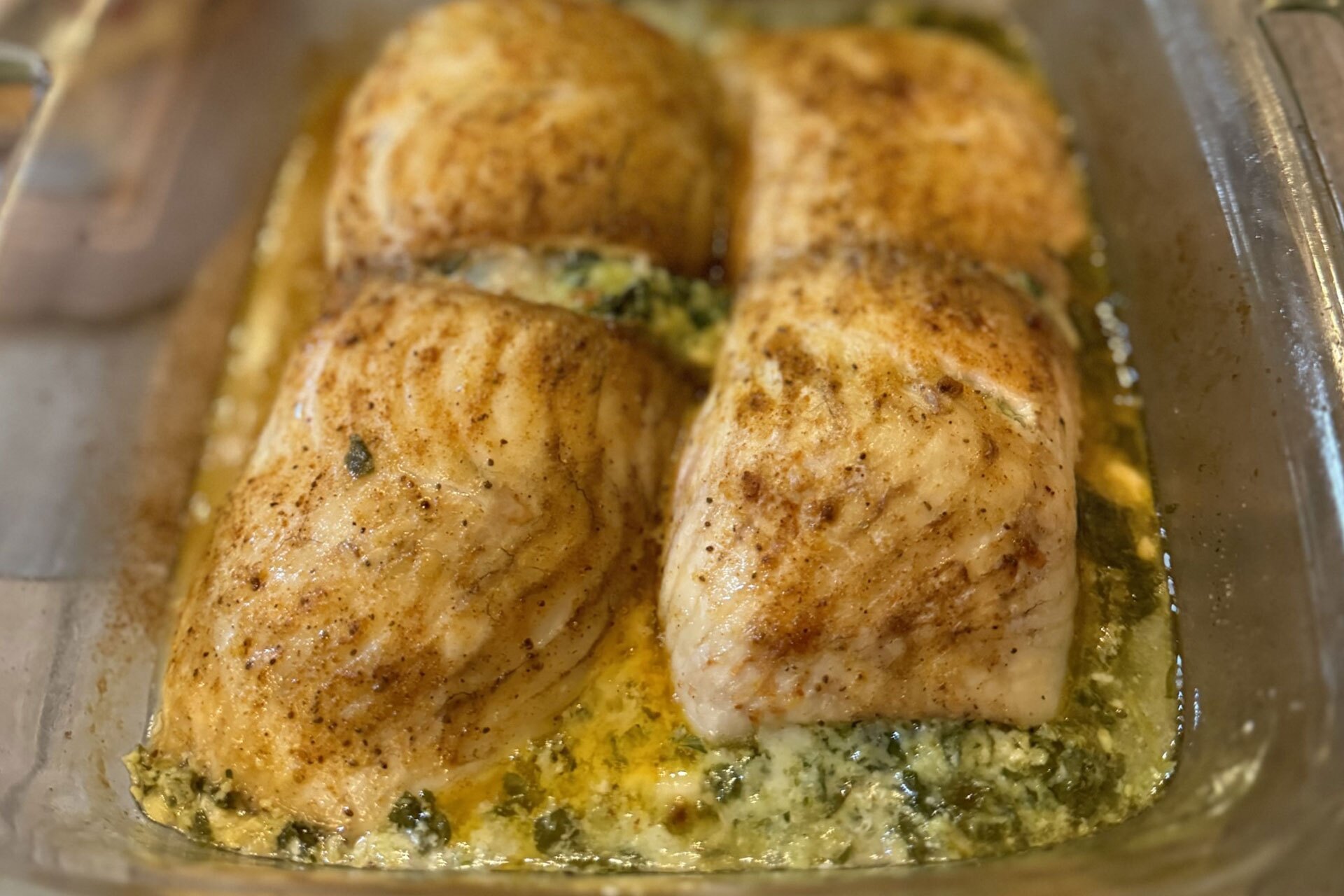 Spinach and feta stuffed flounder in a backing dish.