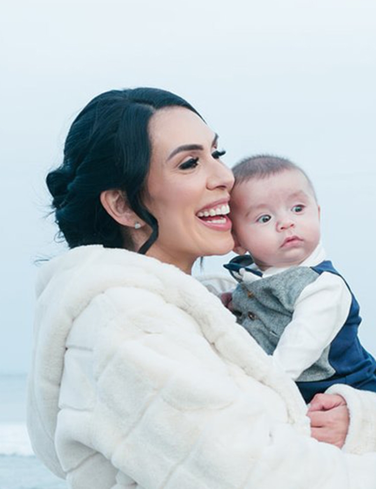 Cropped photo of ALK+ patient Amanda Bialack Stewart holding her baby son.